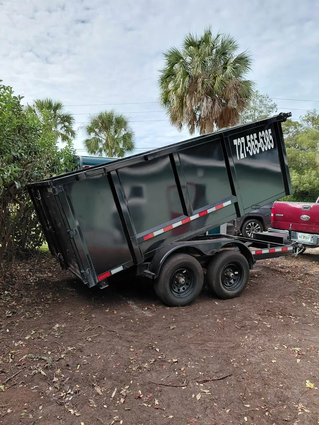 Premier Junk Removal dump trailer at a Pinellas County property